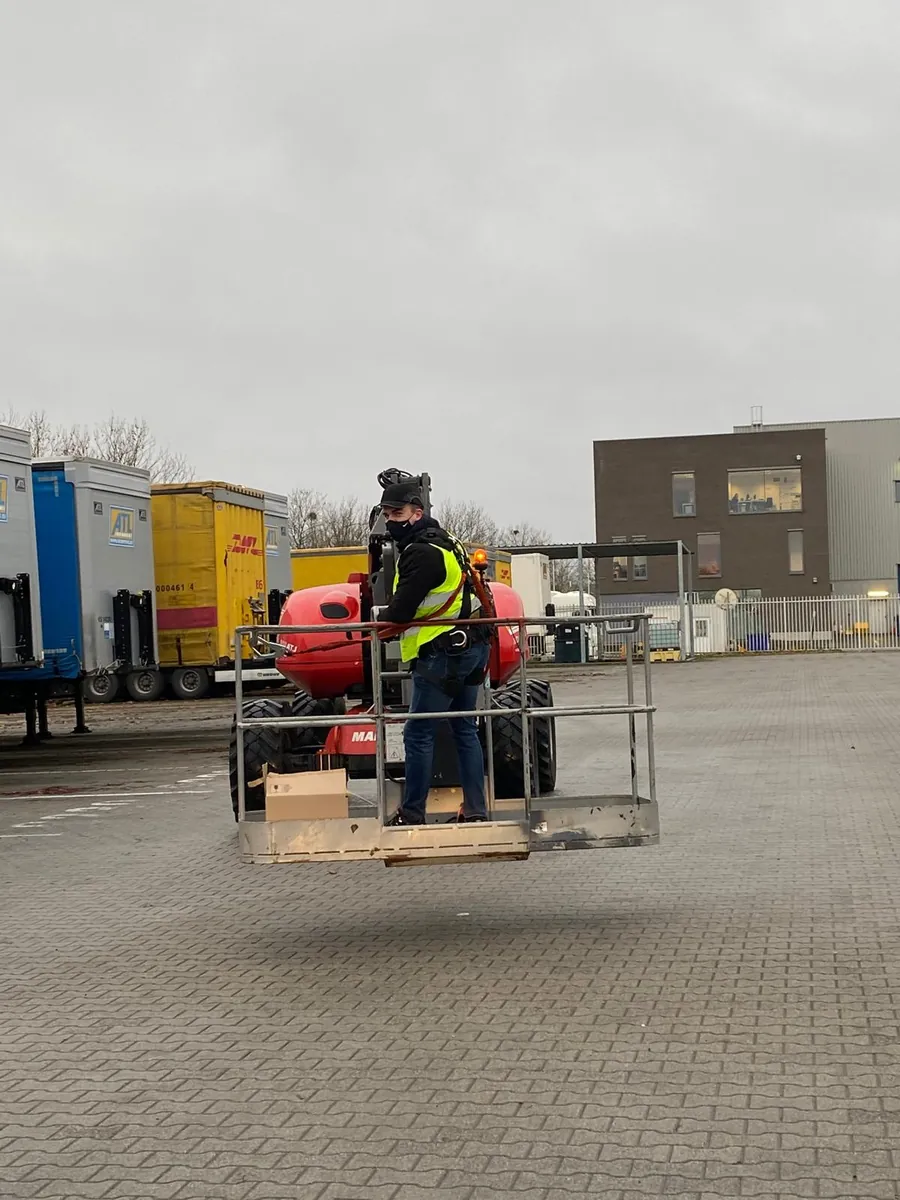 Technieker in de korf van de hoogwerker